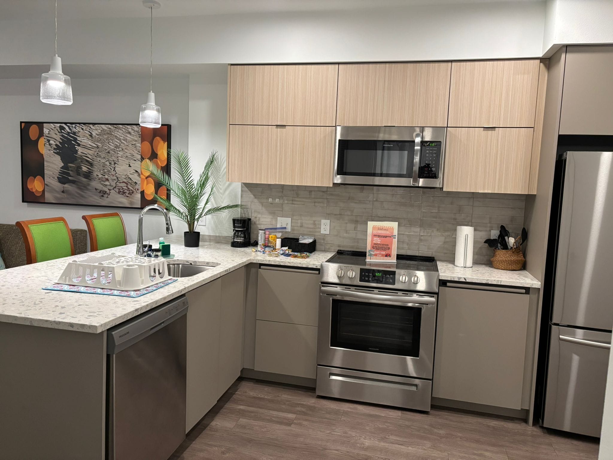 A modern kitchen with stainless steel appliances, a granite countertop, and wooden cabinets.