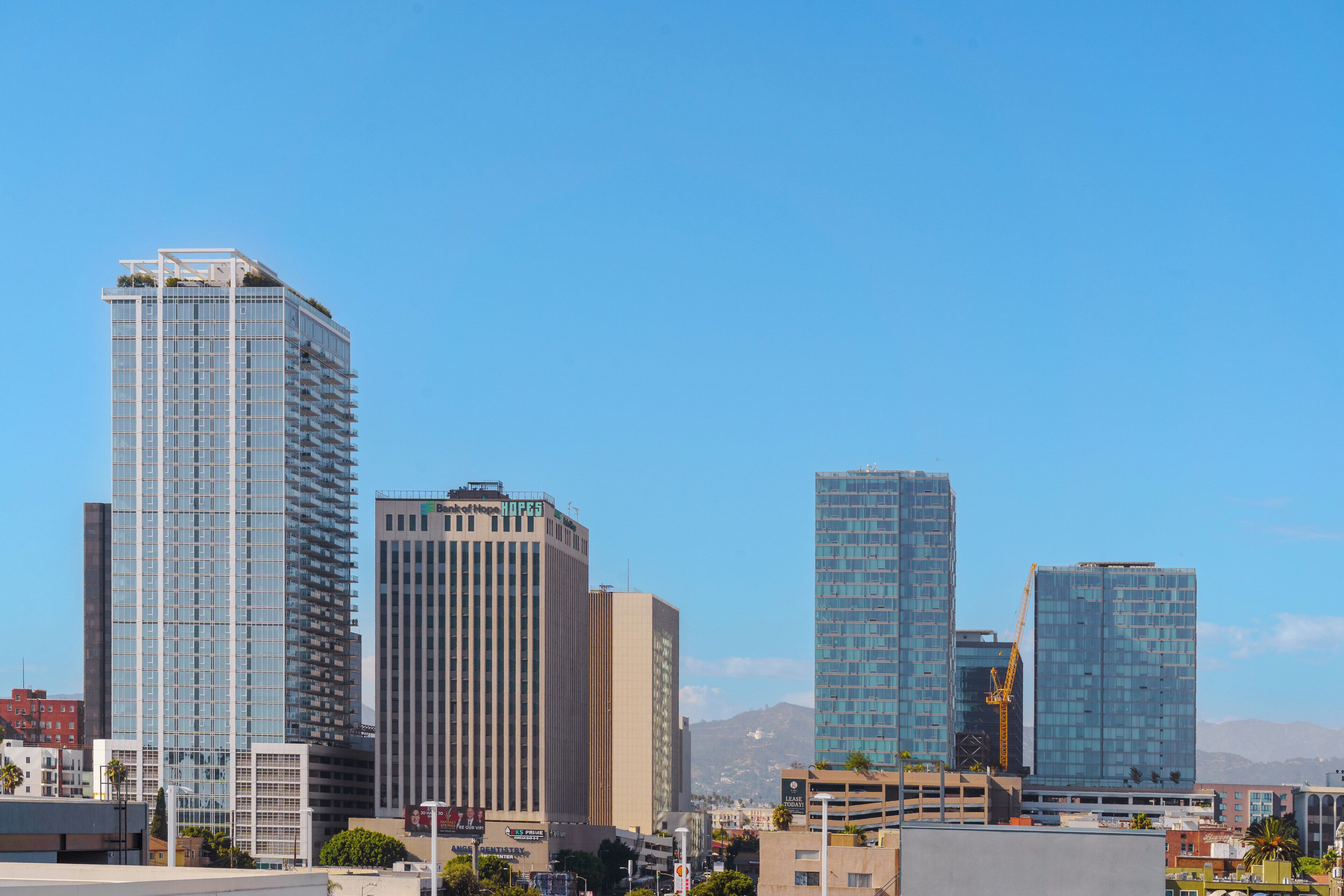 A cityscape with modern high-rise buildings, including a prominent glass-fronted structure.
