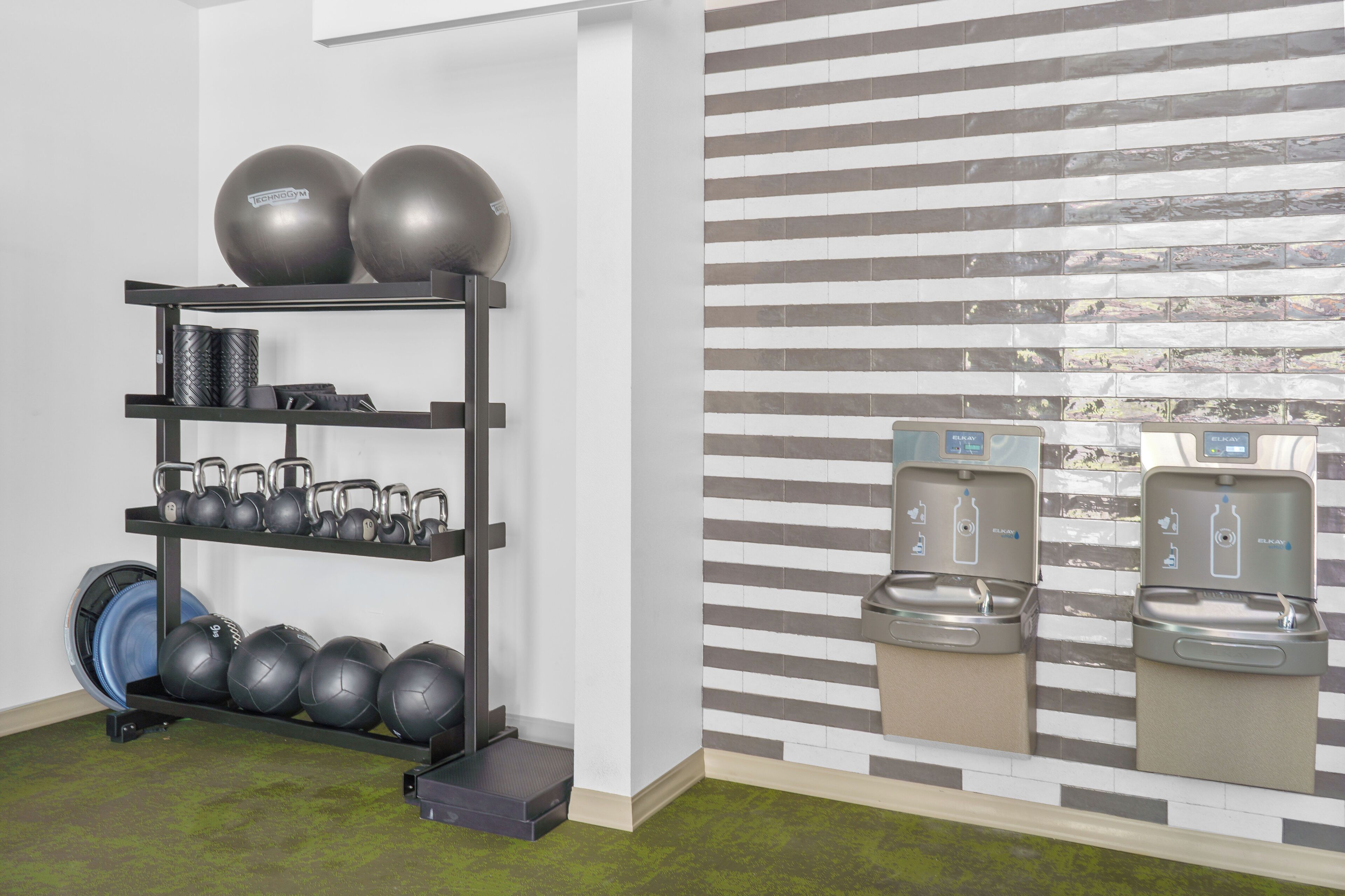 A gym with exercise equipment and water dispensers.