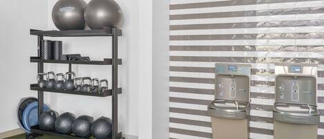 A gym with exercise equipment and water dispensers.