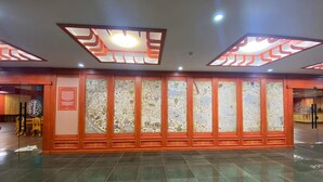 A lobby with a tiled floor, a reception desk, and a wall with decorative panels. - Secret of the Silk Road (Kharkhorin)