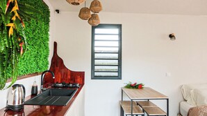 A kitchen with a wooden countertop, a sink, and a window with horizontal blinds.