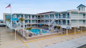 Un hôtel à plusieurs étages doté d’une piscine, de balcons et de bureaux.