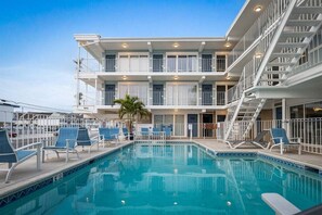 Un hôtel doté d’une piscine, de plusieurs balcons et d’un escalier.