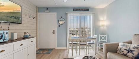 A room with a dining area, a sofa, a ceiling fan, a TV, and a sign reading 'NORTH WILDFORD.'