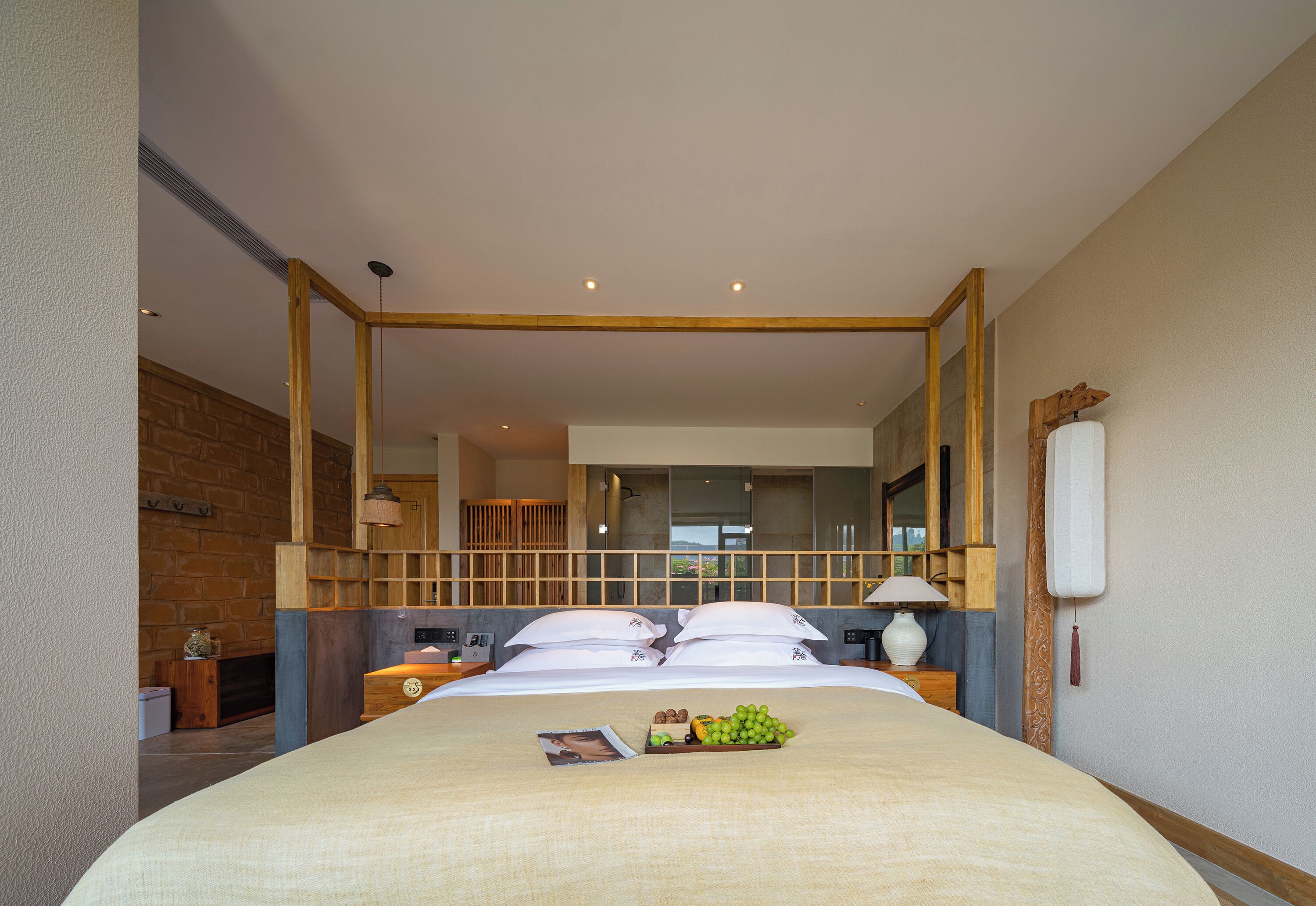 Habitación de hotel con una cama grande, cabecero de madera y vista a la ciudad a través de la ventana.