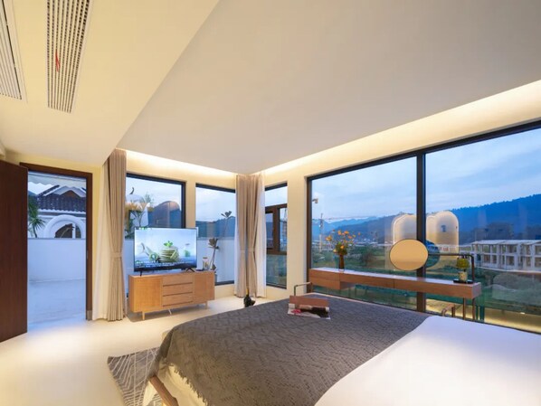 A modern bedroom with a large bed, a desk, and a view of a mountainous landscape through large windows. - Wang Yun Residence Boutique Homestay (Zhangjiajie)