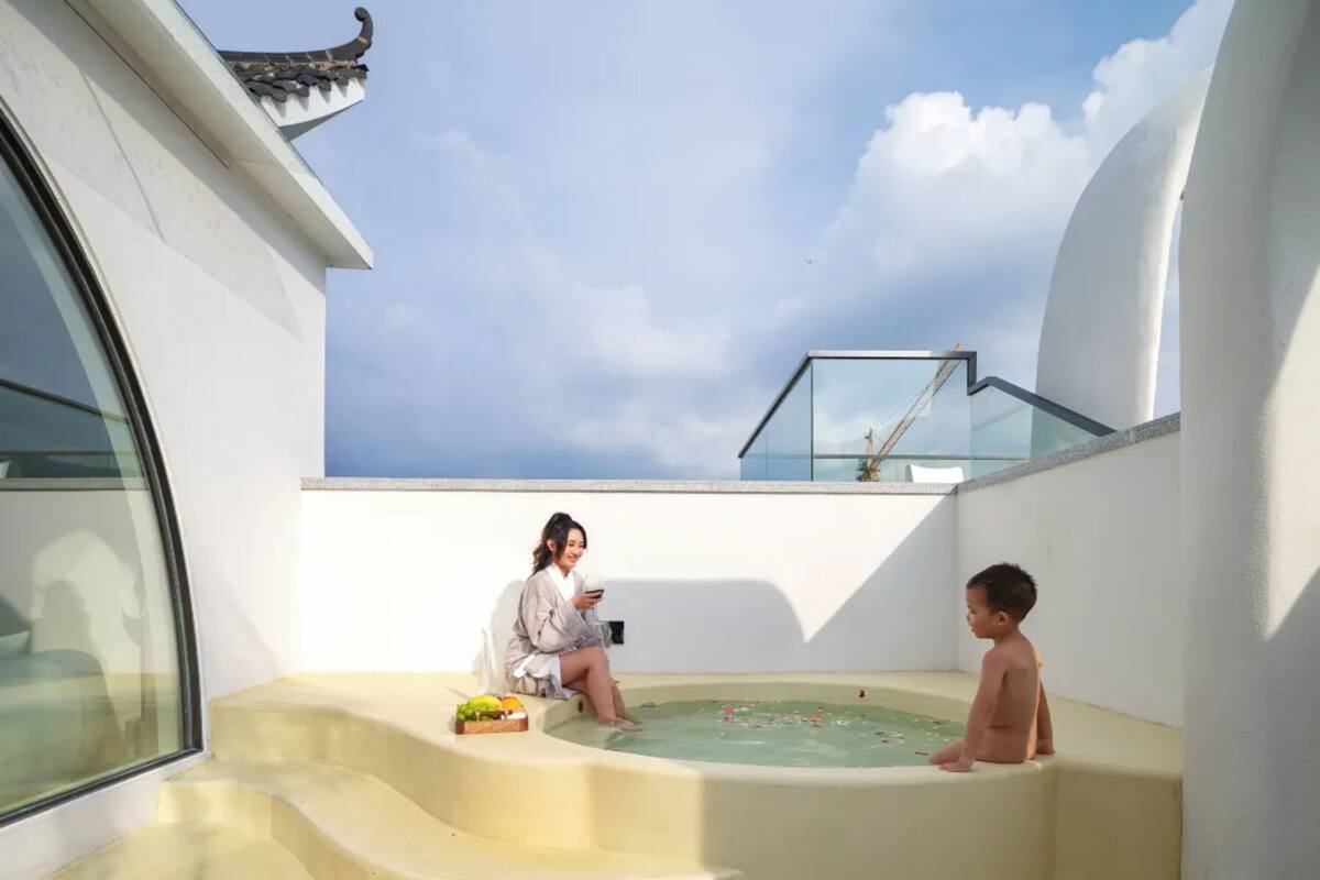 Eine Dachterrasse mit Whirlpool, einem Kind und einer erwachsenen Person.