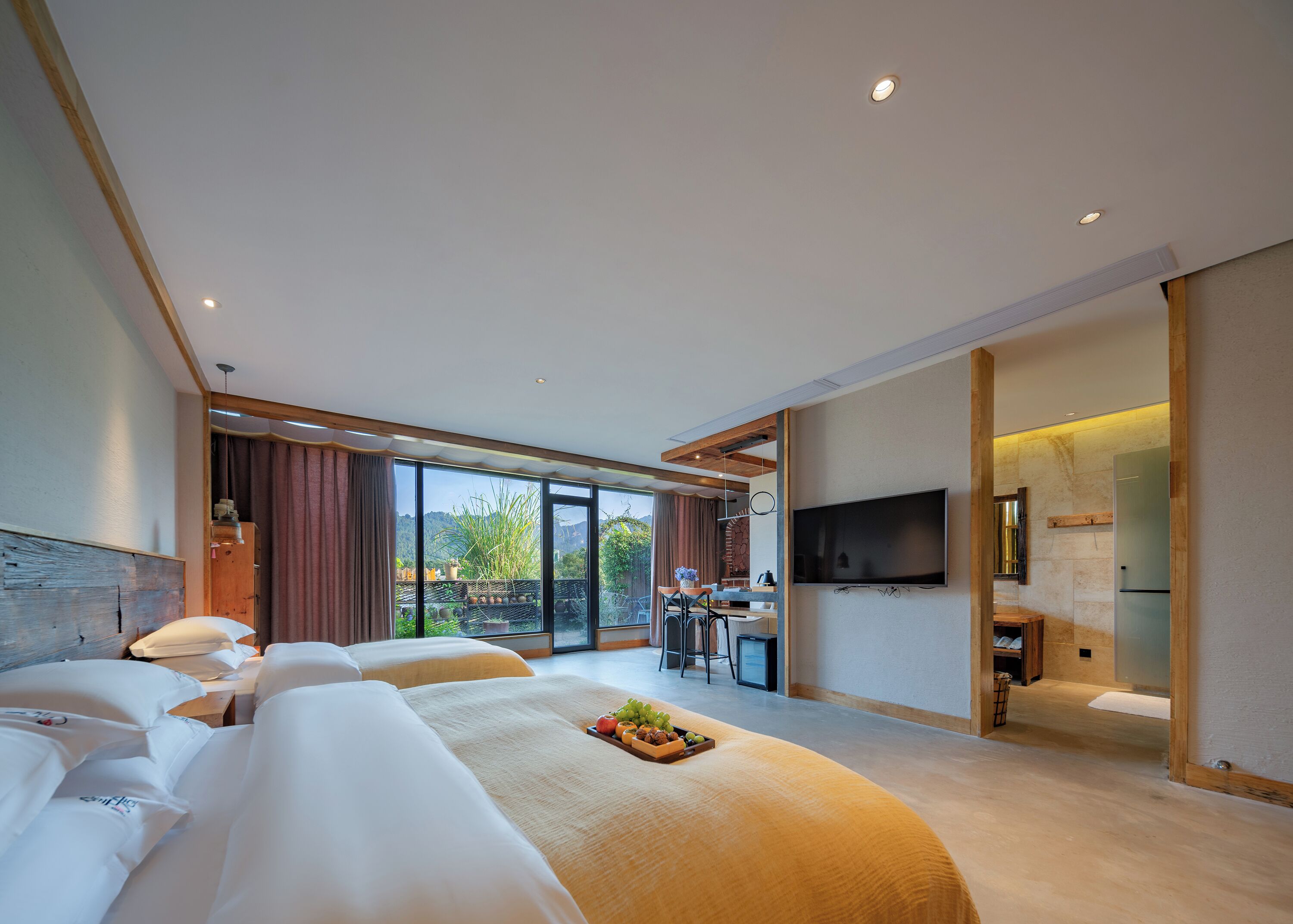 Una camera d'albergo moderna con un letto grande, un'area pranzo e una TV.
