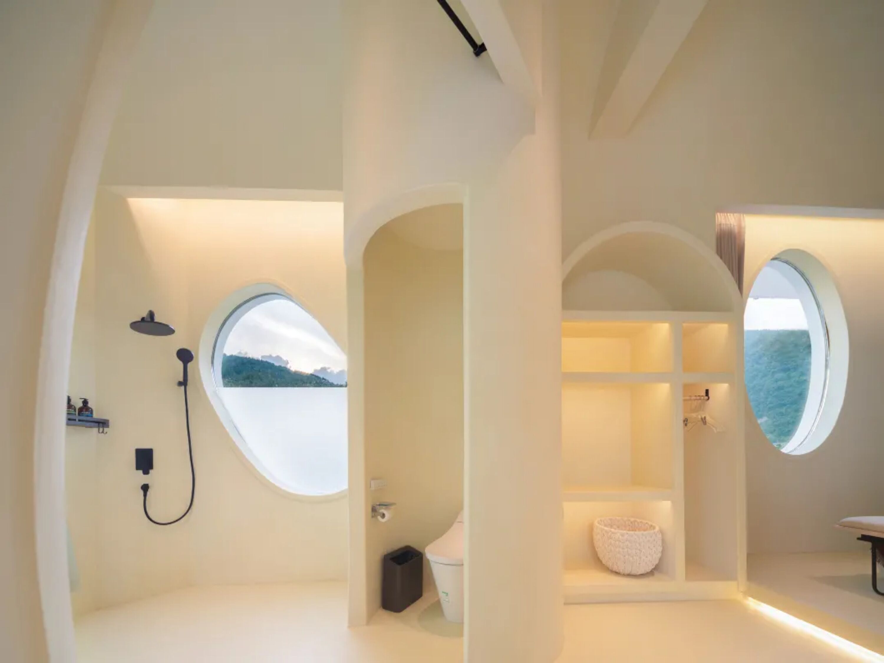 A modern bathroom with a skylight, a shower area, and a view of the sea.