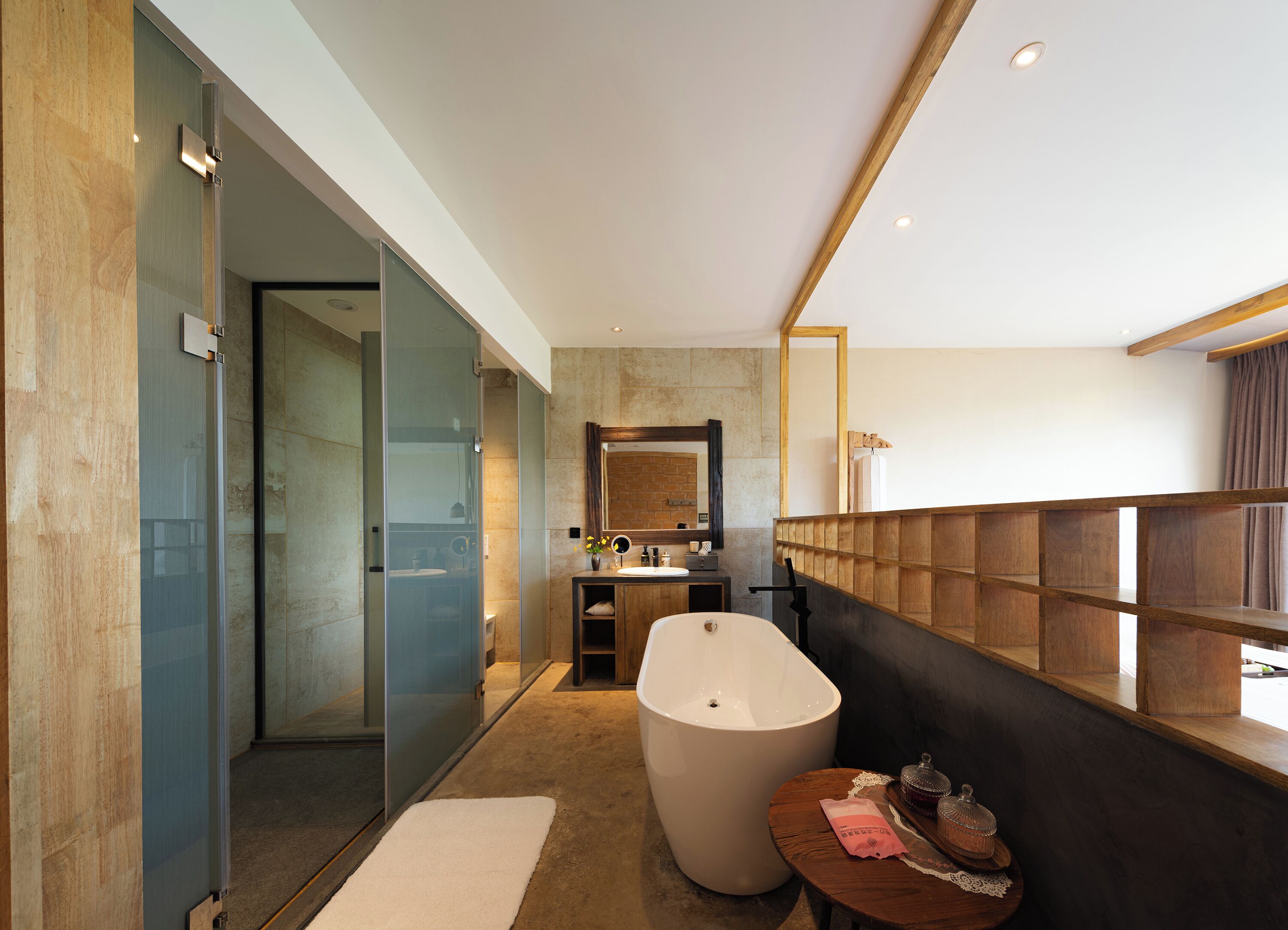 A modern bathroom with a glass-enclosed shower, a freestanding bathtub, and a vanity with a mirror.