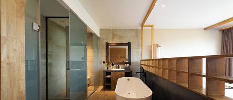 A modern bathroom with a glass-enclosed shower, a freestanding bathtub, and a vanity with a mirror.