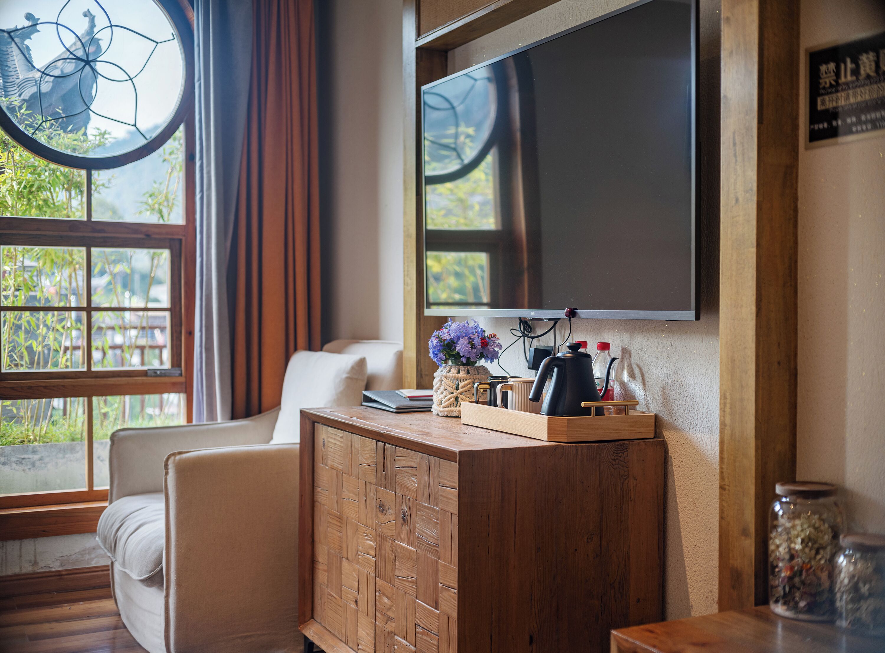 A modern living room with a wooden cabinet, a flat-screen TV, and a comfortable sofa.