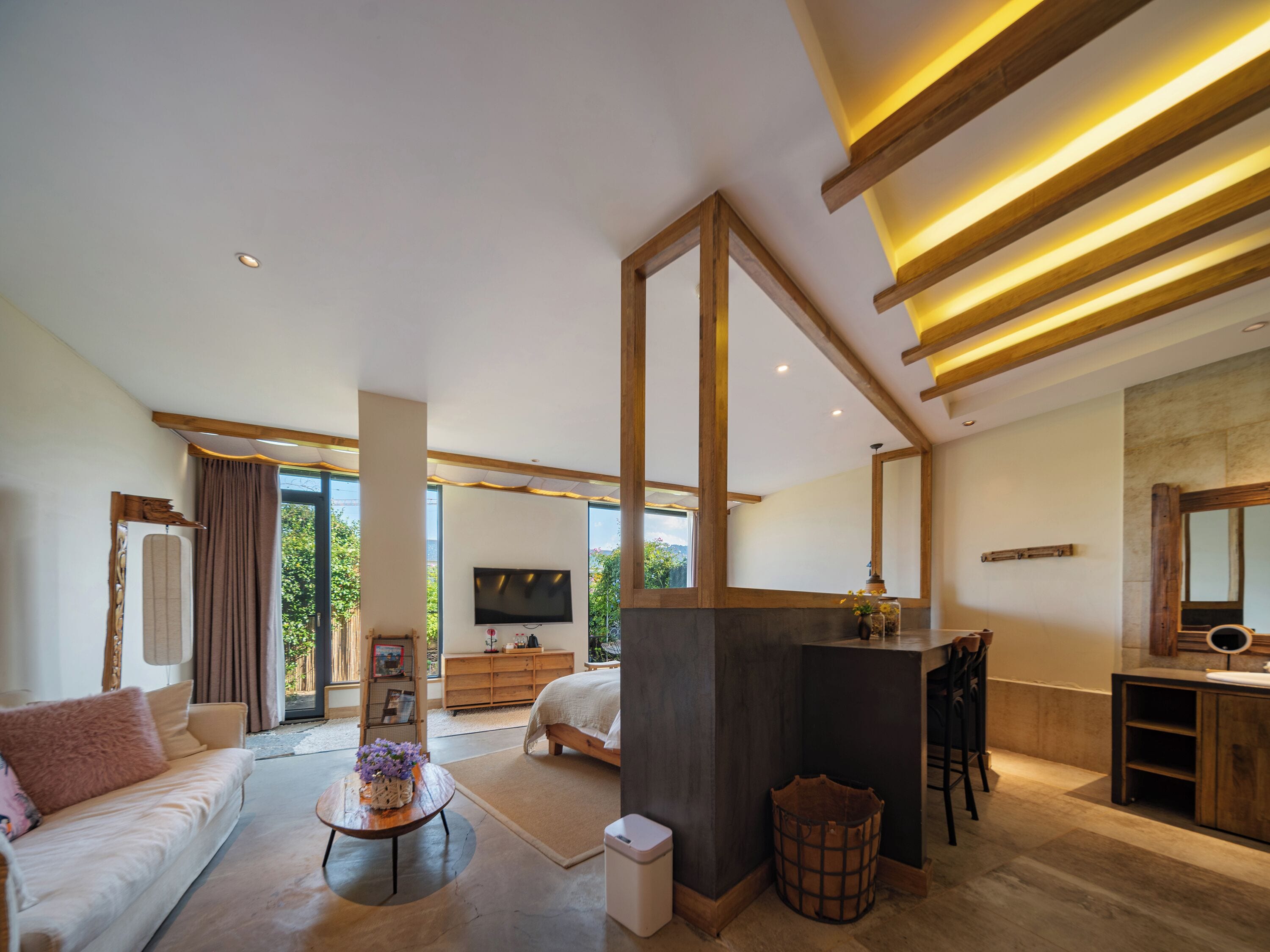 A modern bedroom with a large bed, a TV, and a wooden ceiling.