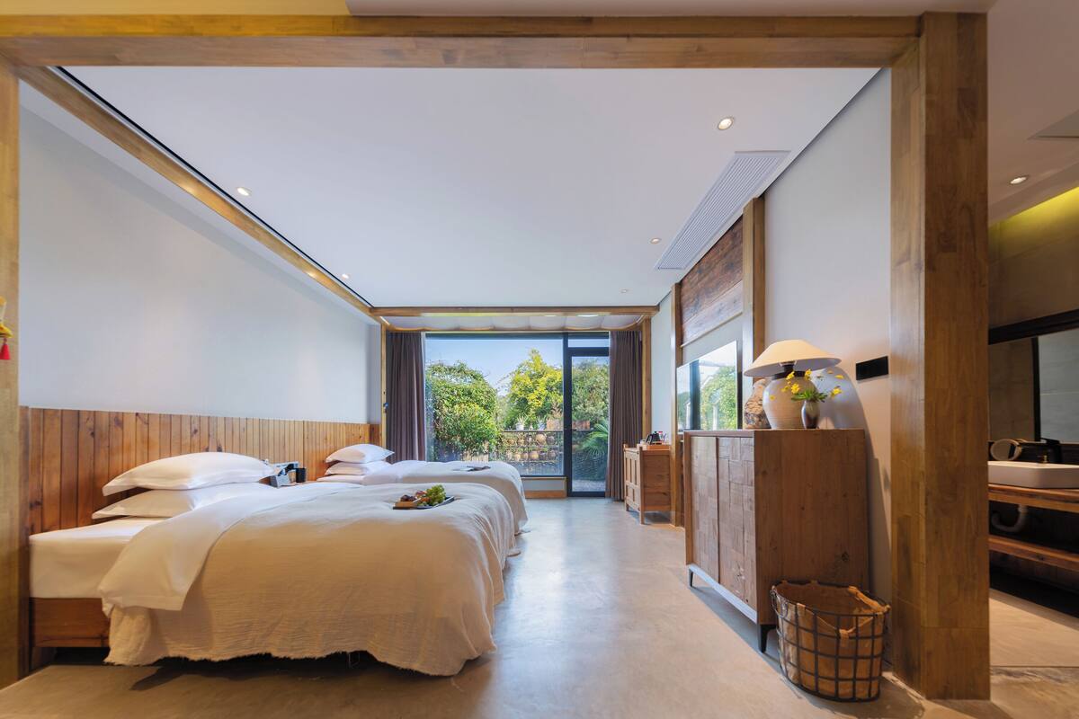 Ein modernes Hotelzimmer mit einem großen Bett, einem Schreibtisch und Blick ins Freie.