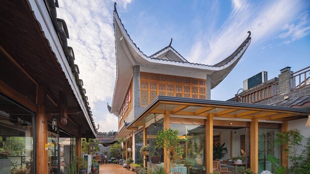 Il s’agit d’un bâtiment traditionnel, doté d’un toit en pente et d’une structure en bois, entouré de plantes en pot et agrémenté d’une terrasse en bois.
