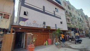A hotel named "MELVYAT" with a signboard, wooden entrance, and potted plants outside. - Hotel M Hyatt (Hyderabad)