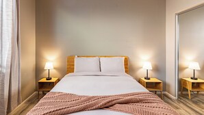 A neatly made bed with white linens, two bedside lamps, and a wooden headboard. - Luxe Indio Stay w/ Pool, Tiki Bar & Fire Pit Near Coachella | Longfellow (Indio)