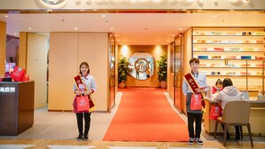 The entrance of Haidilao Hot Pot with a red carpet, a reception desk, and a display of hot pot products. - Vinhomes Central Park Landmark Apartment (Ho Chi Minh City)