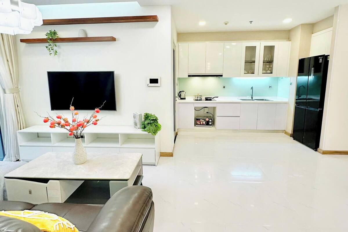 A modern living room with a sofa, a flat-screen TV, and a coffee table.