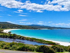 A coastal landscape with a clear sky, a beach, and a road leading to the shore. - Lichen Villa Bay of Fires  - Binalong Bay beach is at your doorstep (Binalong Bay)