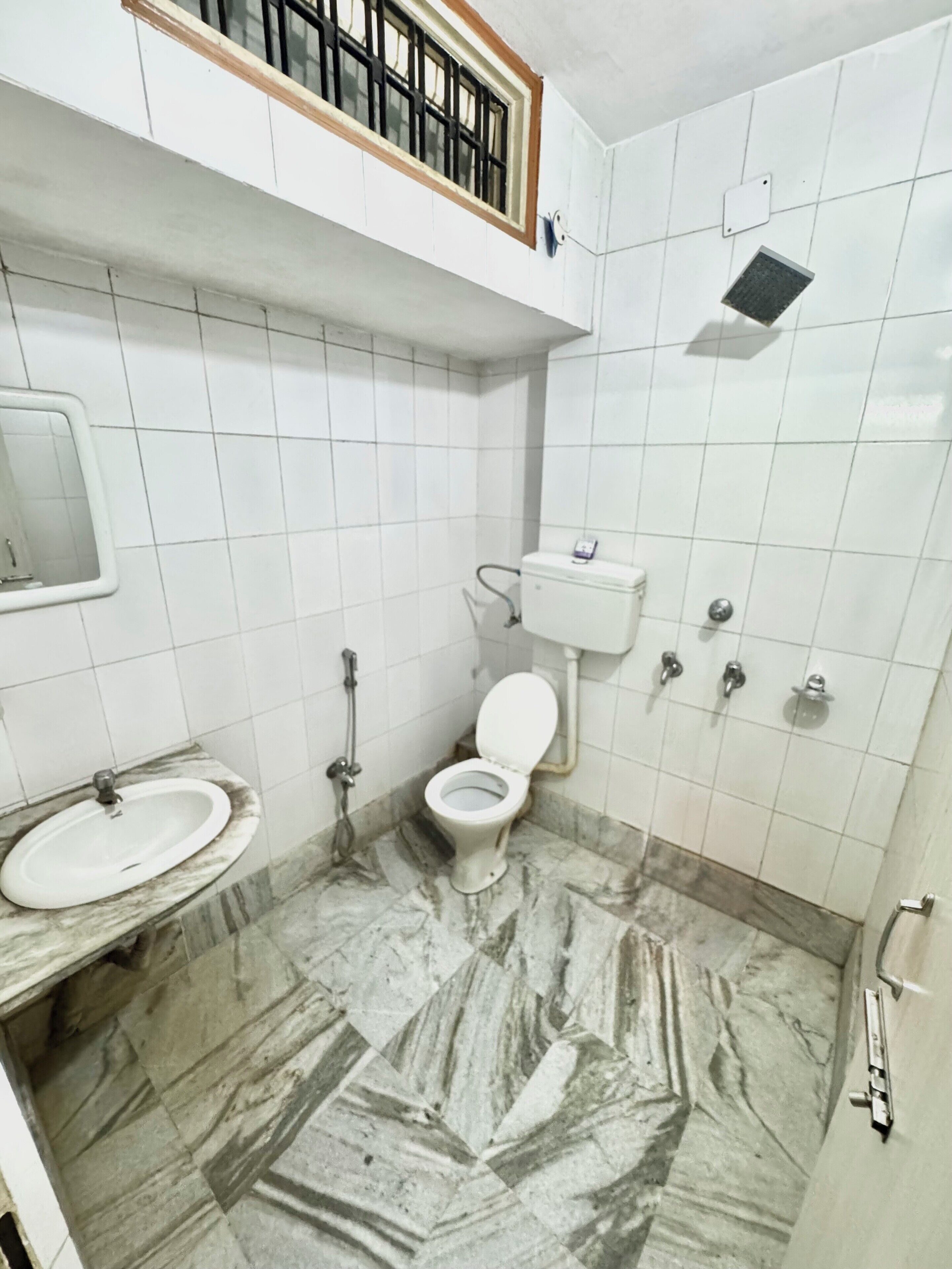 A bathroom with a toilet, sink, and shower.