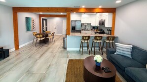 Een moderne woonkamer met een eethoek, keuken en een bar.