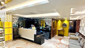 A modern hotel lobby with a reception desk, seating area, and decorative elements. - Onyx Garden Boutique Hotel (Guwahati)