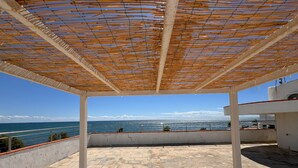 Un espacio al aire libre techado con vistas al mar y a las montañas.