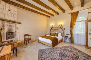 A bedroom with a bed, a chair, a table, a rug, and a decorative wall.