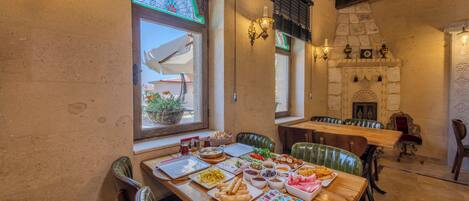 Un comedor con una mesa de madera dispuesta para una comida, mostrando diferentes platos y una variedad de bebidas.