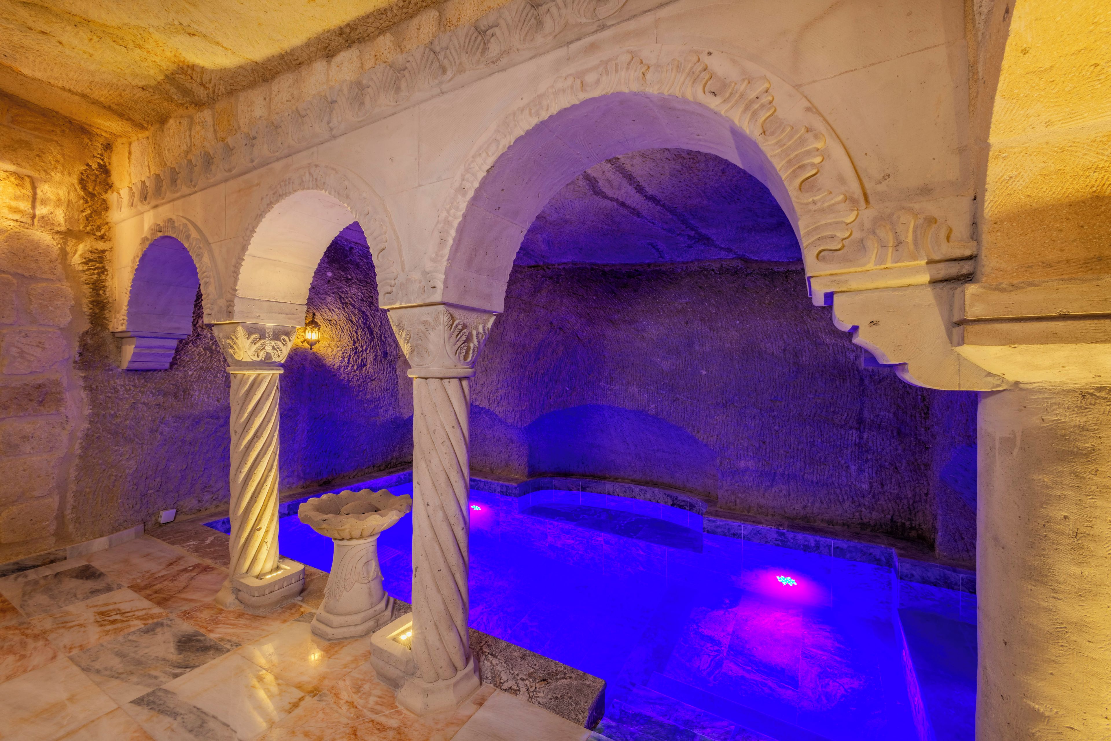Un interior histórico con arcos de piedra, columnas y suelo de baldosas.