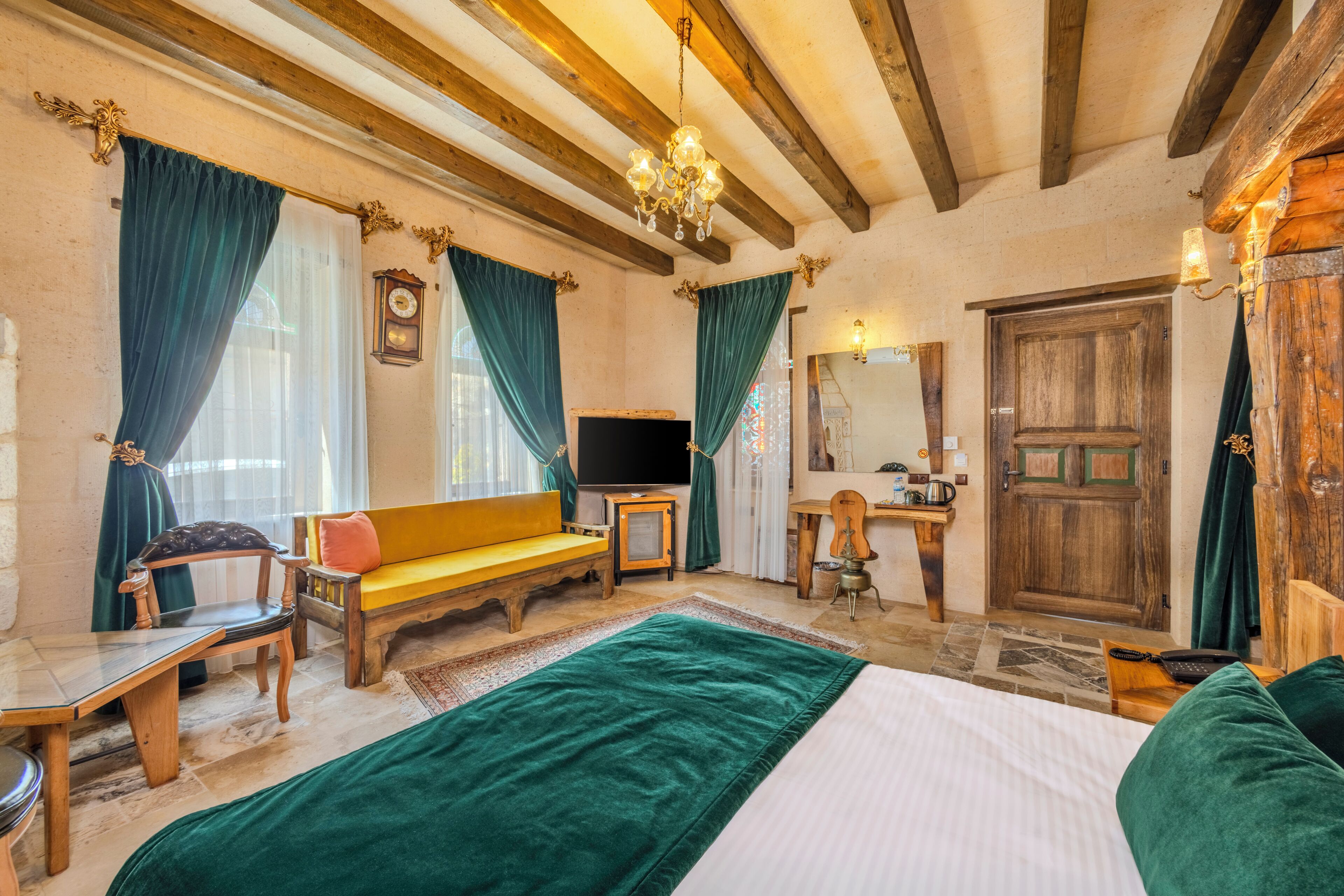 Una habitación tradicional con una cama, muebles de madera, un televisor y una puerta de madera.