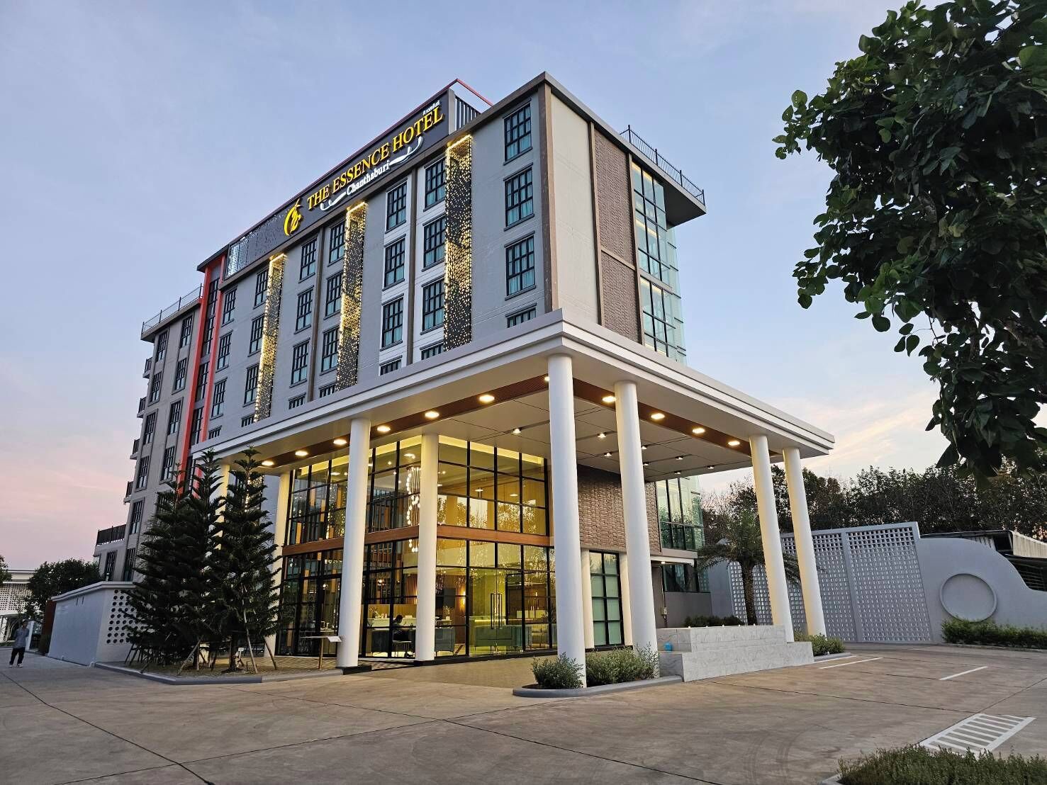 A modern hotel building with a prominent entrance and a covered area.