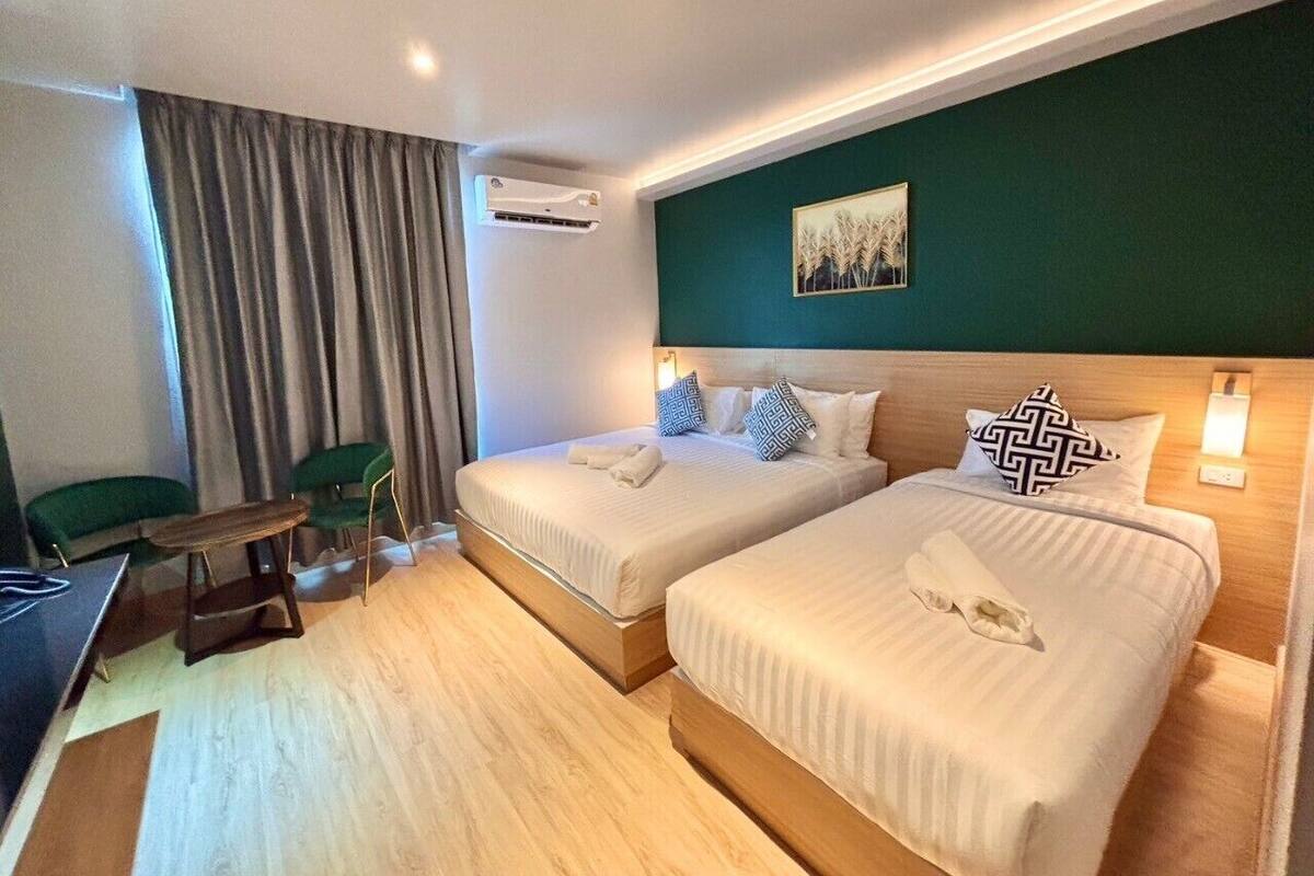 A hotel room with two beds, a desk, and a chair.