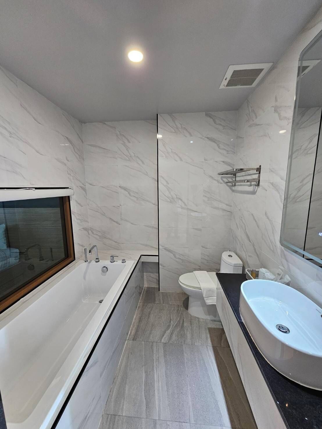 Un baño moderno con una bañera amplia, un lavamanos independiente y un inodoro.