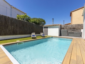 A swimming pool with two lounge chairs, a barbecue area, and a tall fence. - La Manzaneta by Interhome (St Antoni de Calonge)