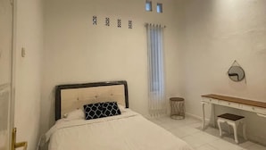 A bedroom with a bed, a desk, and a chair. - Hotel O Bogor near Taman Safari formerly Villa Ruko (Cisarua)