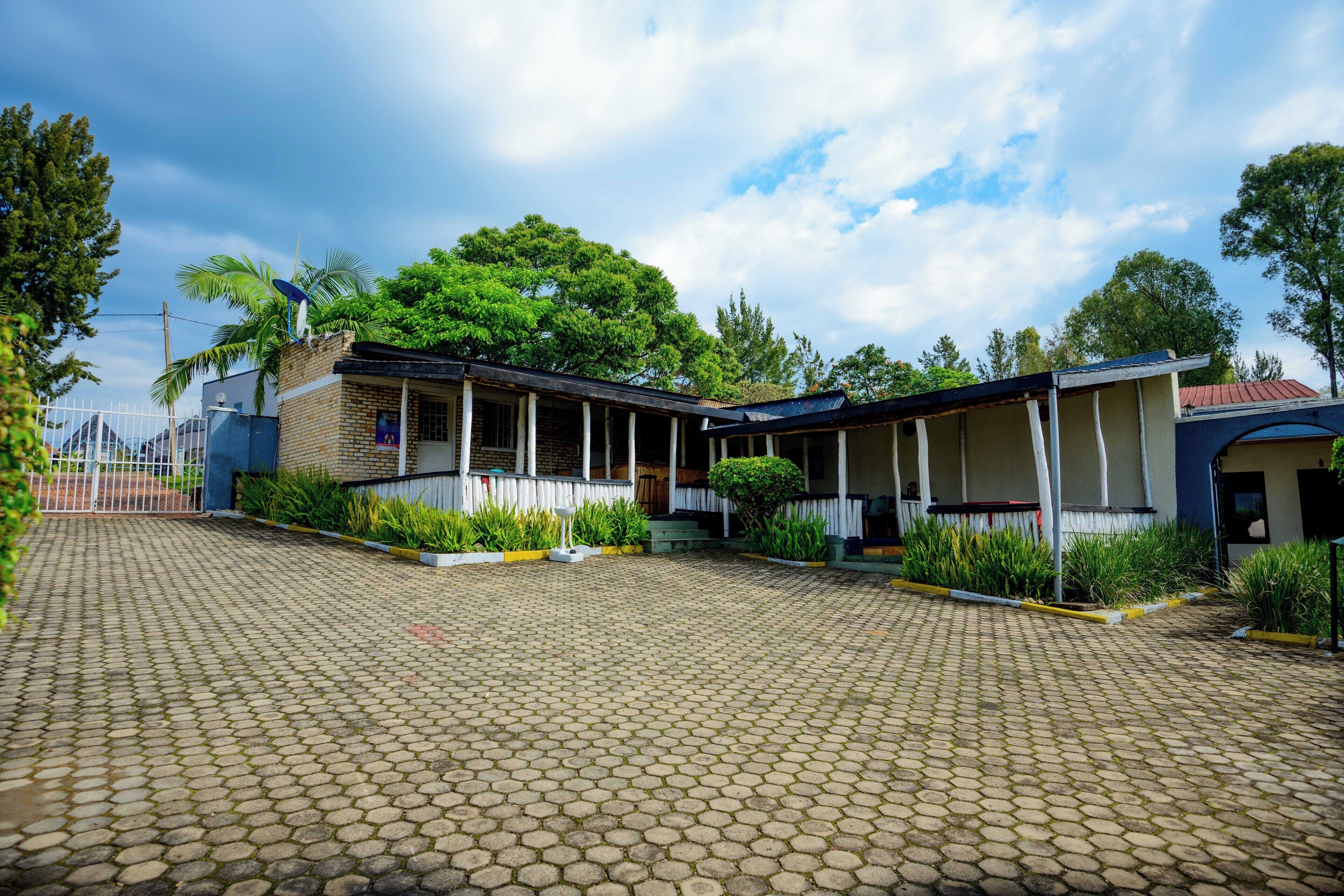 A building with a covered porch and a paved courtyard.