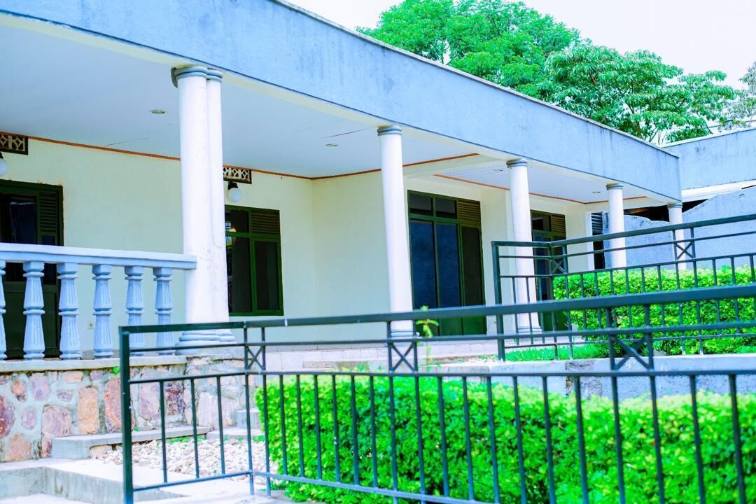 A building with a covered entrance, columns, and a stone wall.