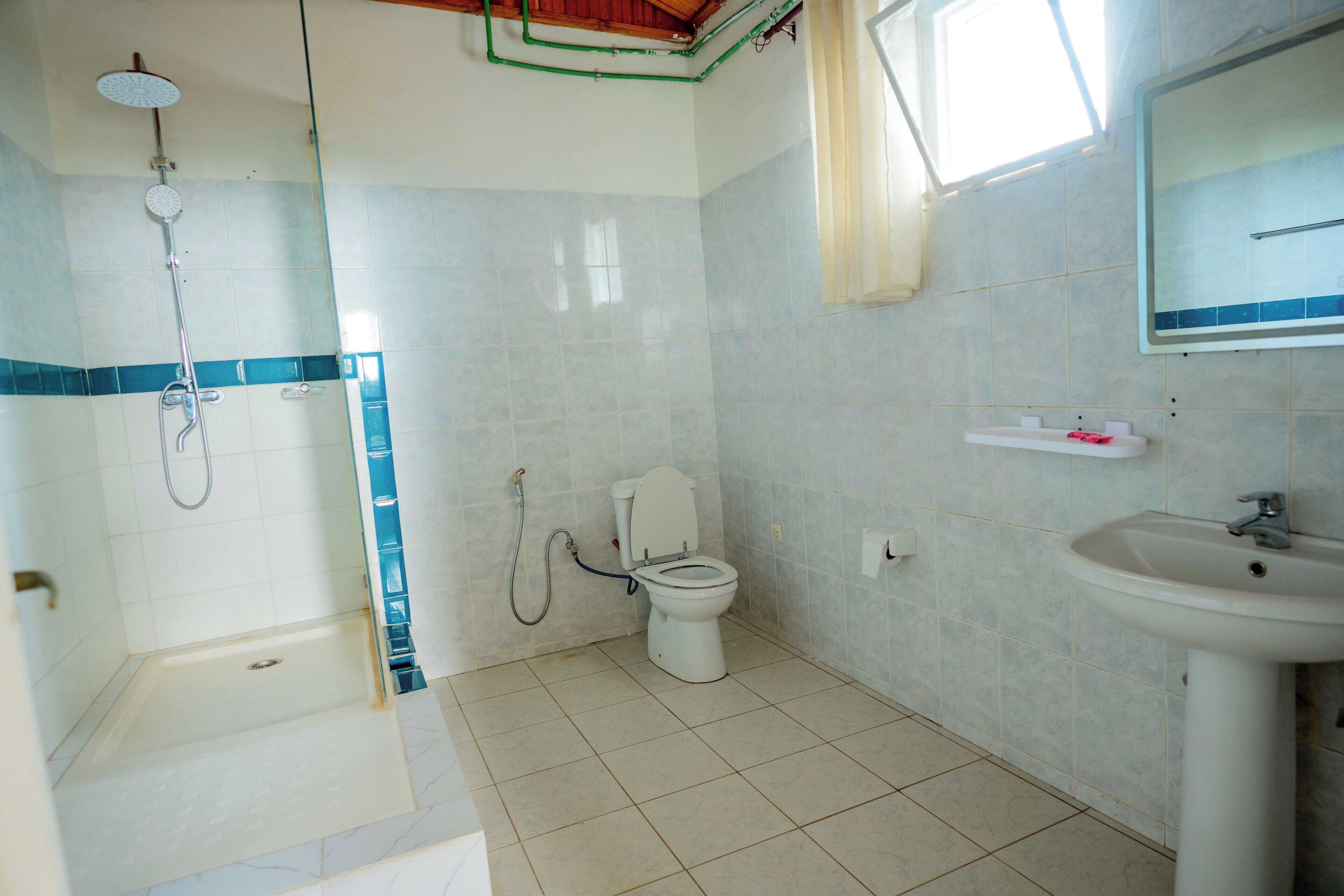 Une salle de bain avec une douche, des toilettes et un lavabo.