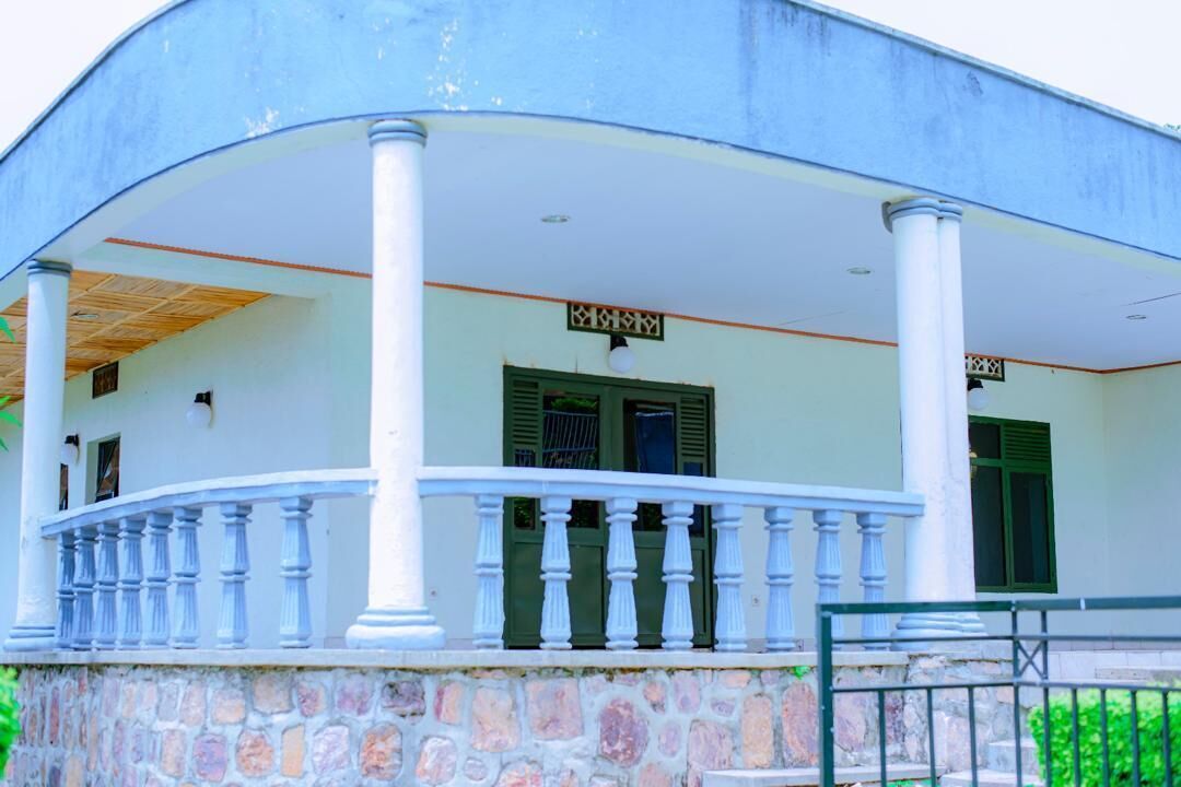 A building with a curved facade, white columns, and a balcony with balustrades.