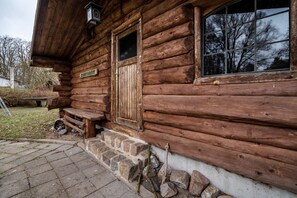 A wooden cabin with a stone foundation, a wooden door, and a window. - Apartment 3 – Natural Retreat for Relaxation (Lychen)