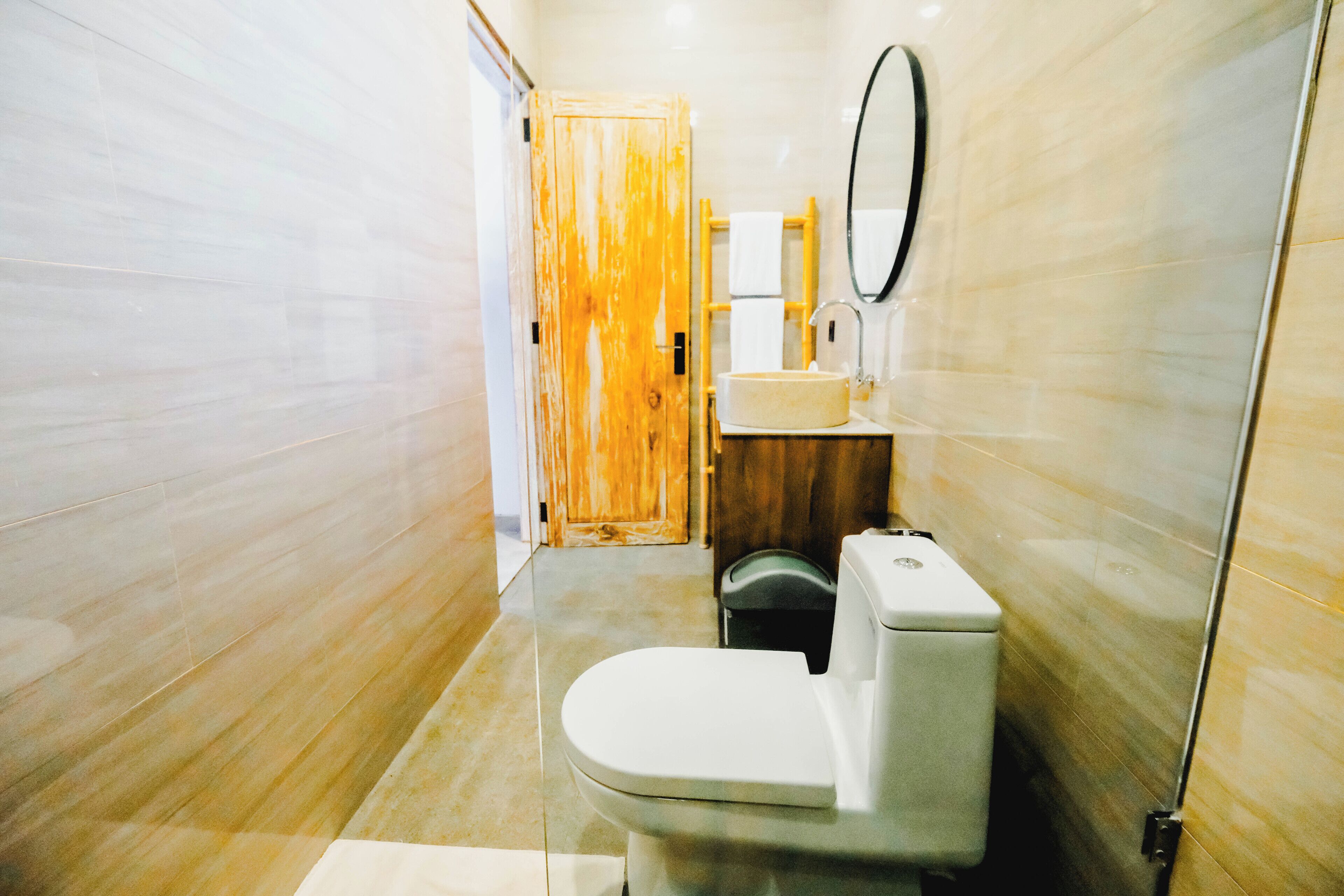 A bathroom with a toilet, sink, and mirror.