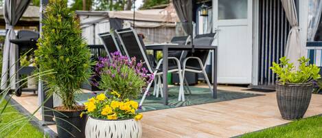 A patio area with outdoor furniture, potted plants, and a covered seating area.