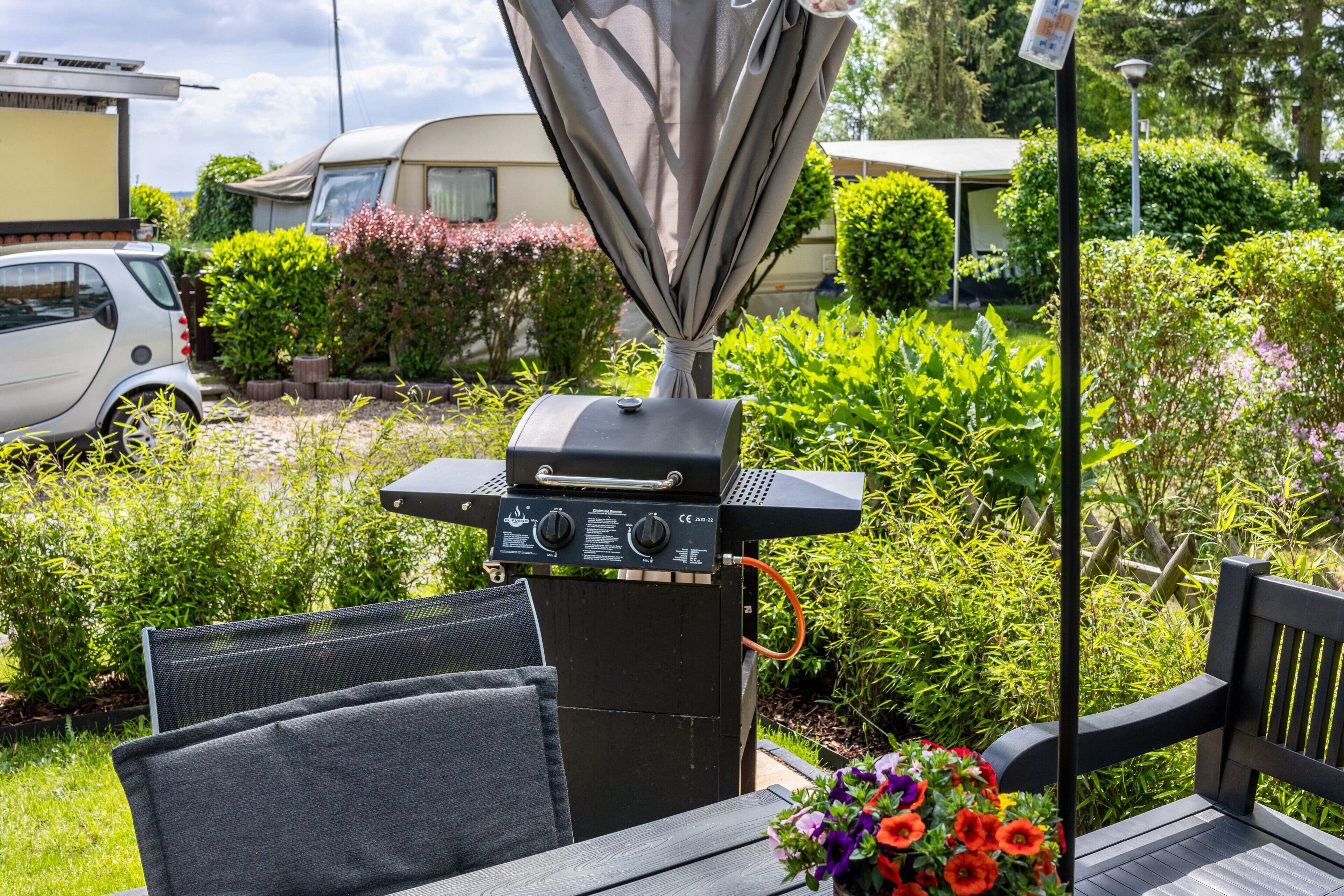 Eine Terrasse mit Grill, Stuhl und Tisch.