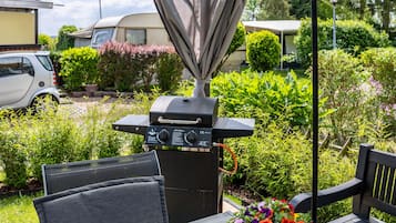 Eine Terrasse mit Grill, Stuhl und Tisch.