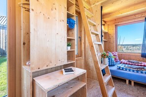 A wooden interior with a ladder, shelves, a bed, and a window. - Tiny House 'Tanne' in the Heart of the Northern Black Forest (Schömberg)