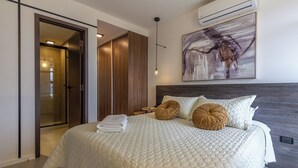 Un dormitorio moderno con una cama grande, un vestidor y un cuadro en la pared.