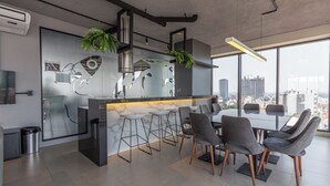 Una cocina moderna con encimera de mármol, taburetes de bar y vistas a la ciudad.